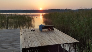 A wooden pier extending into a body of water with a sunset in the background. - Holiday Home Villa Pippilotta (Userin)