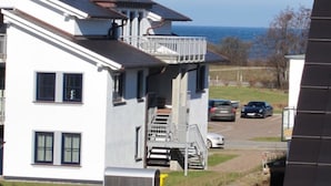 A two-story house with a balcony, a garage, and a driveway. - Apartment Achtern Meer II (Boergerende-Rethwisch)