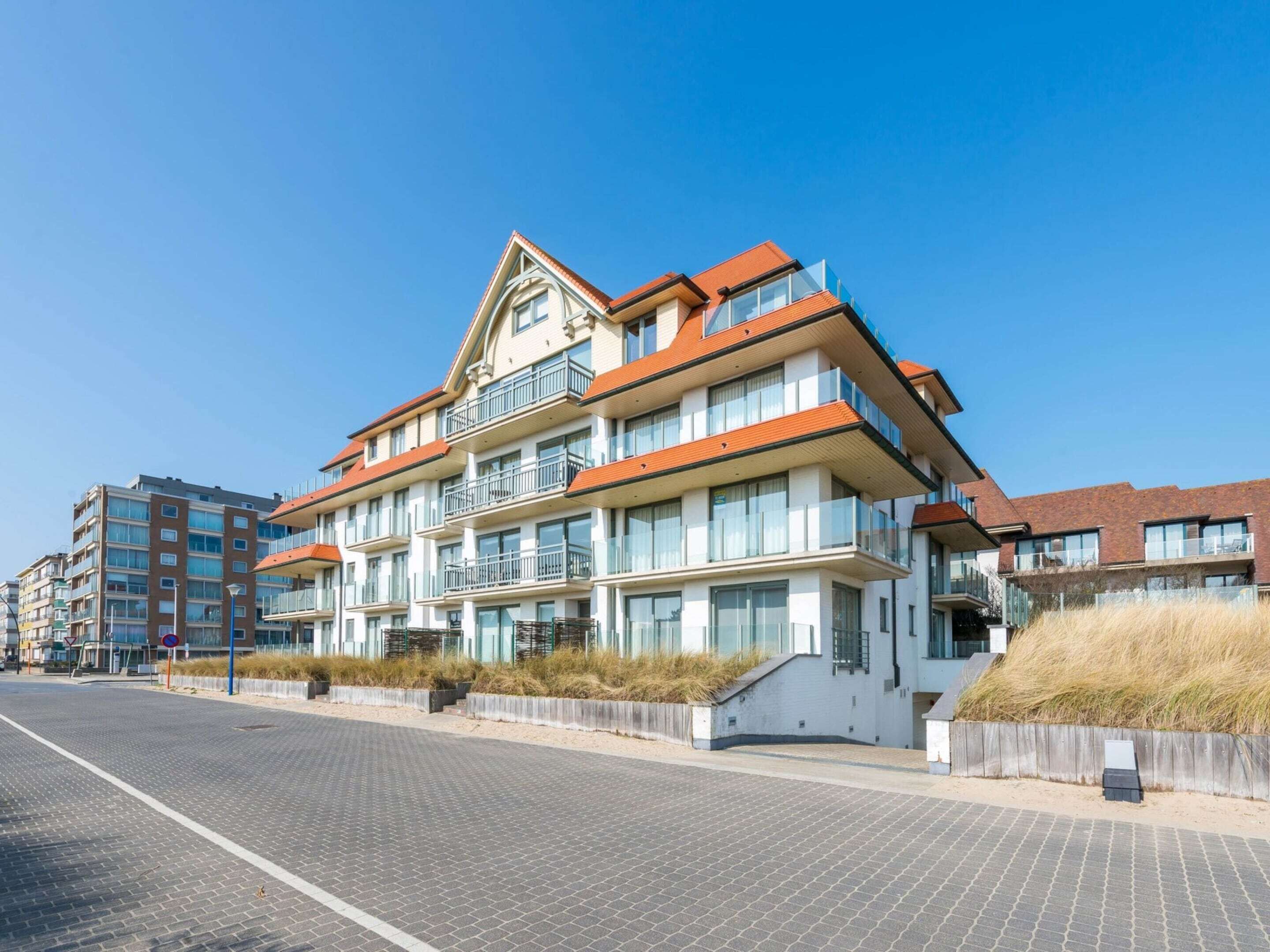 A multi-story hotel with balconies, a brick facade, and a paved walkway.