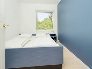A bedroom with a bed, a window, and a nightstand. - 6 Person Holiday Home in Gilleleje (Gilleleje)