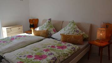 Ein Schlafzimmer mit Bett, Nachttisch, Stuhl und Lampe.