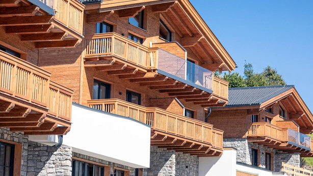 Ein mehrstöckiges Holzgebäude mit Balkonen und Steinmauern.