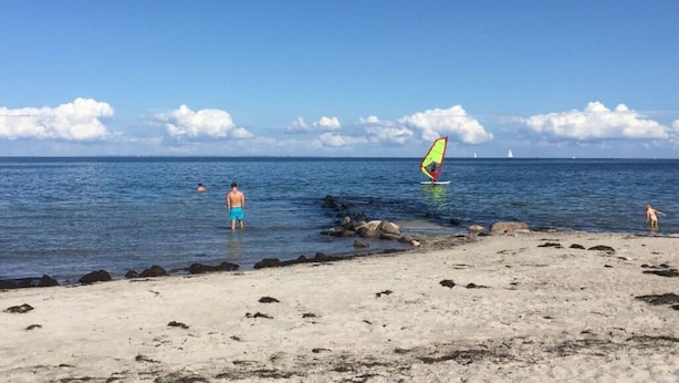 A beach with clear skies, calm water, and a few people. - Nordgluck Modern Retreat (Taarstedt)