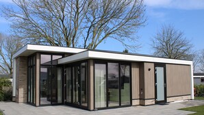 A modern two-story building with large glass windows and a flat roof. - Apartment With Sauna and Terrace in Gelderland (Lathum)