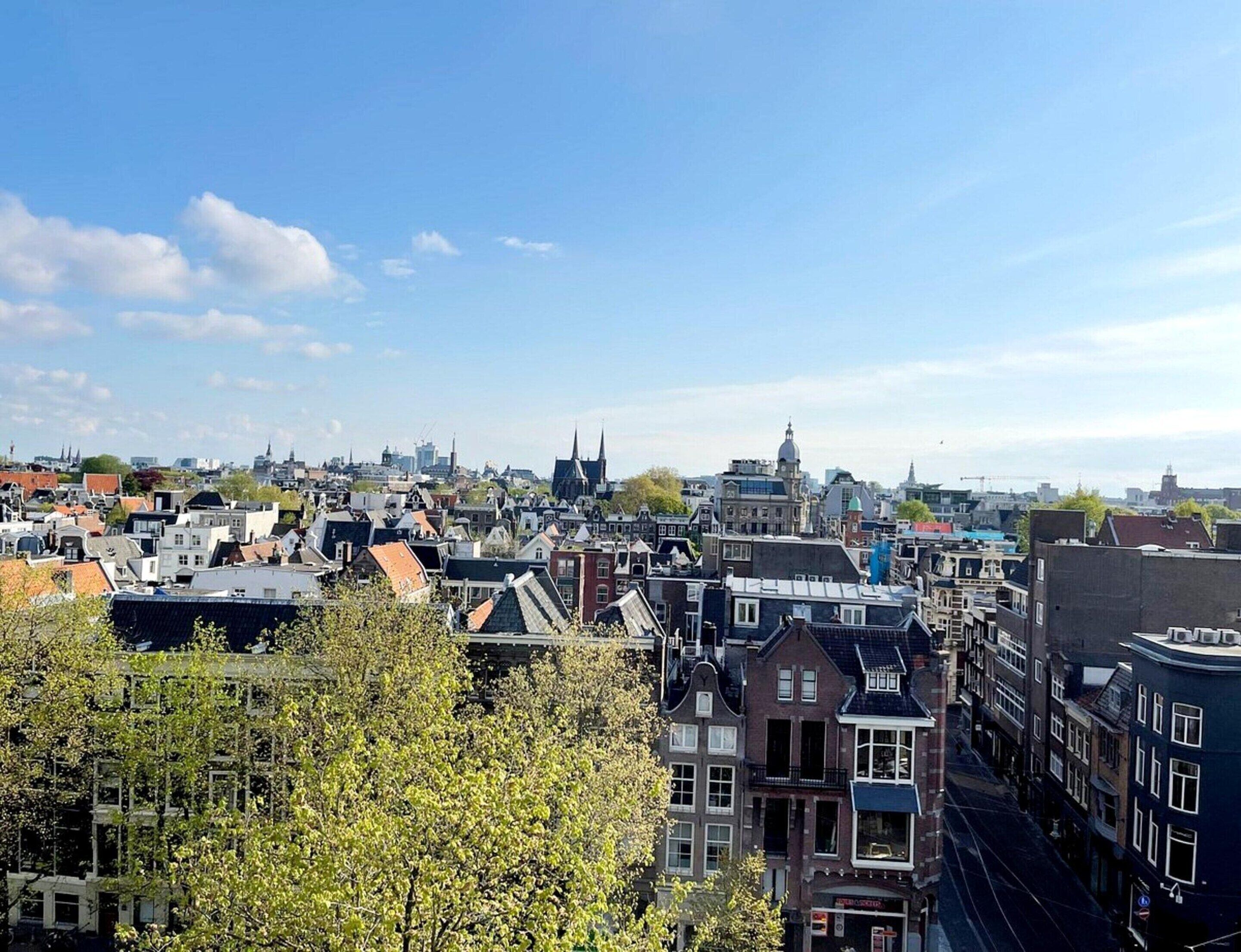 Un paysage urbain avec des bâtiments historiques, une église imposante et une ligne de tramway.