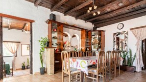 A dining area with a wooden table and chairs, a tiled floor, and a rustic ceiling. - Belvilla by OYO Casa Tata (Granadilla de Abona)