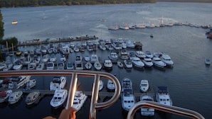 A marina with numerous boats docked, a pier extending into the water, and a forested shoreline in the background. - Holiday Home Lalelu Comfortable Vacation Home (Jabel)