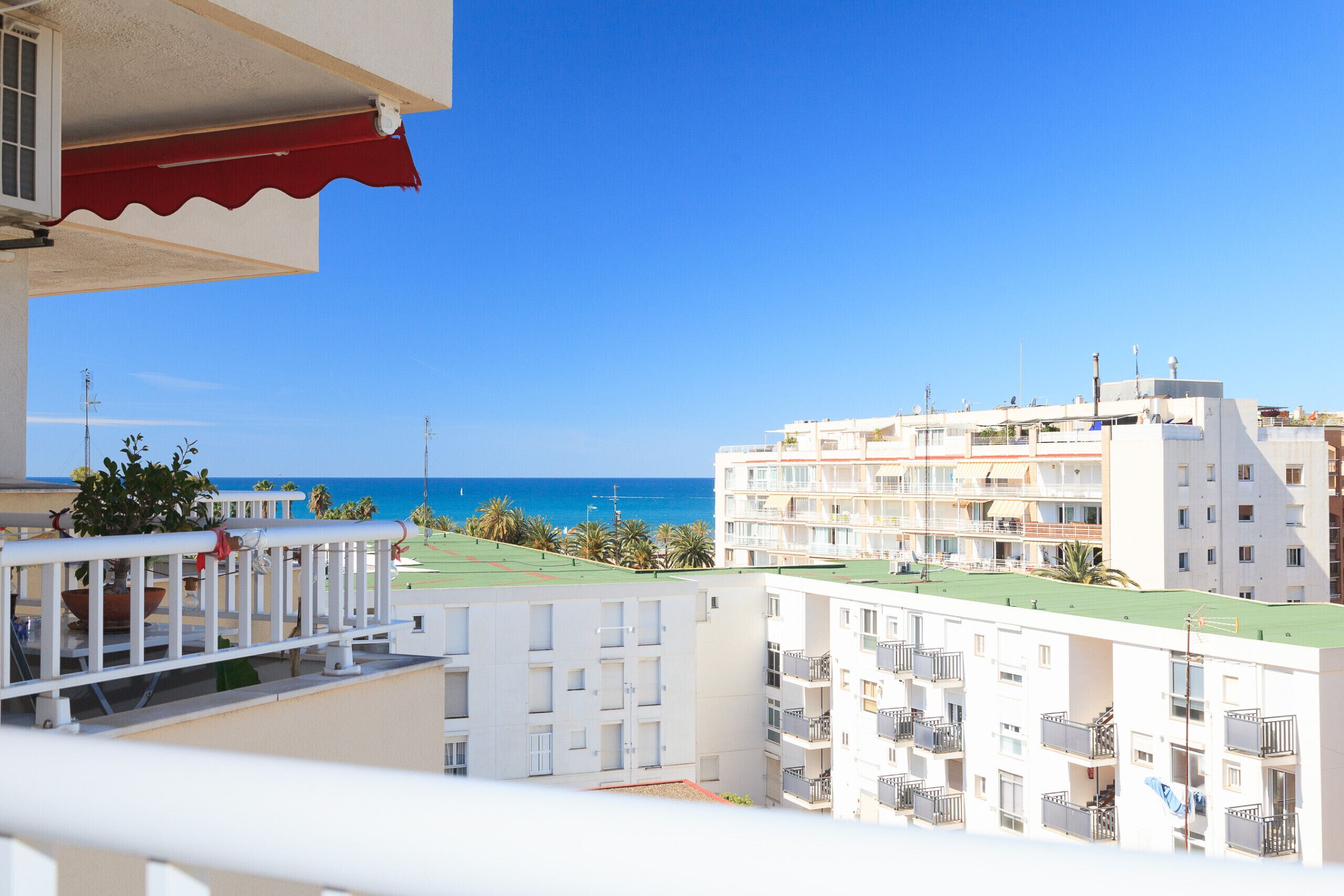 Un immeuble résidentiel doté de balcons, offrant une vue sur la mer et s’ouvrant sur un ciel dégagé.
