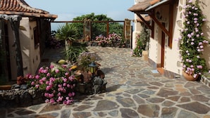 A courtyard with stone flooring, potted plants, and a small fountain. - Holiday Home Finca (Icod de los Vinos)