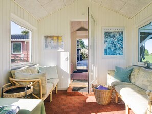 A cozy room with wicker furniture, a view of the outside, and a framed artwork on the wall. - 5 Star Holiday Home in Slagelse (Slagelse)