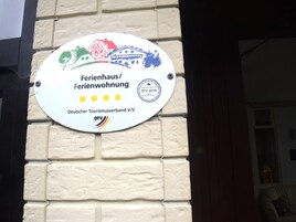 Una placa en la pared con el nombre de un hotel y su logotipo.