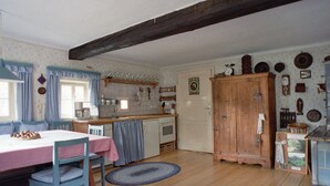 A traditional kitchen with wooden cabinets, a dining table with chairs, and a kitchen counter. - The Holler Comfortable Holiday Residence (Schwanberg)