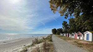 Un sentier bordé de cabanes de plage qui mène à la mer.