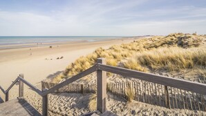 A beach with a wooden staircase leading down to the sand, a sandy dune, and the ocean in the background. - Apartment in Nieuwpoort for 6 Persons (Nieuwpoort)