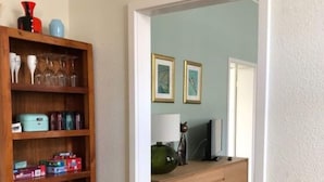 A room with a wooden bookshelf, a wooden dresser, and a dining table. - Stadthaus Emmy Marxen (Schleswig)