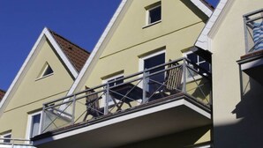 Eine Reihe gelber Gebäude mit dreieckigen Dächern und Balkonen.