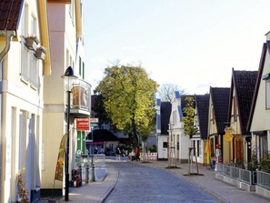 A cobblestone street lined with traditional European buildings, a large tree, and a sign for a hotel named "Natur Hotel." - On the old River Modern Retreat (Rostock)