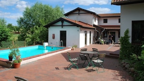A swimming pool with a brick patio and outdoor seating area. - Wohnung in Dargun mit Pool und Streichelzoo (Dargun)