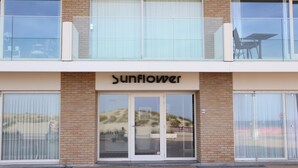 A building with a sign reading "Sunflower" above the entrance. - Apartment in Nieuwpoort With sea View (Nieuwpoort)