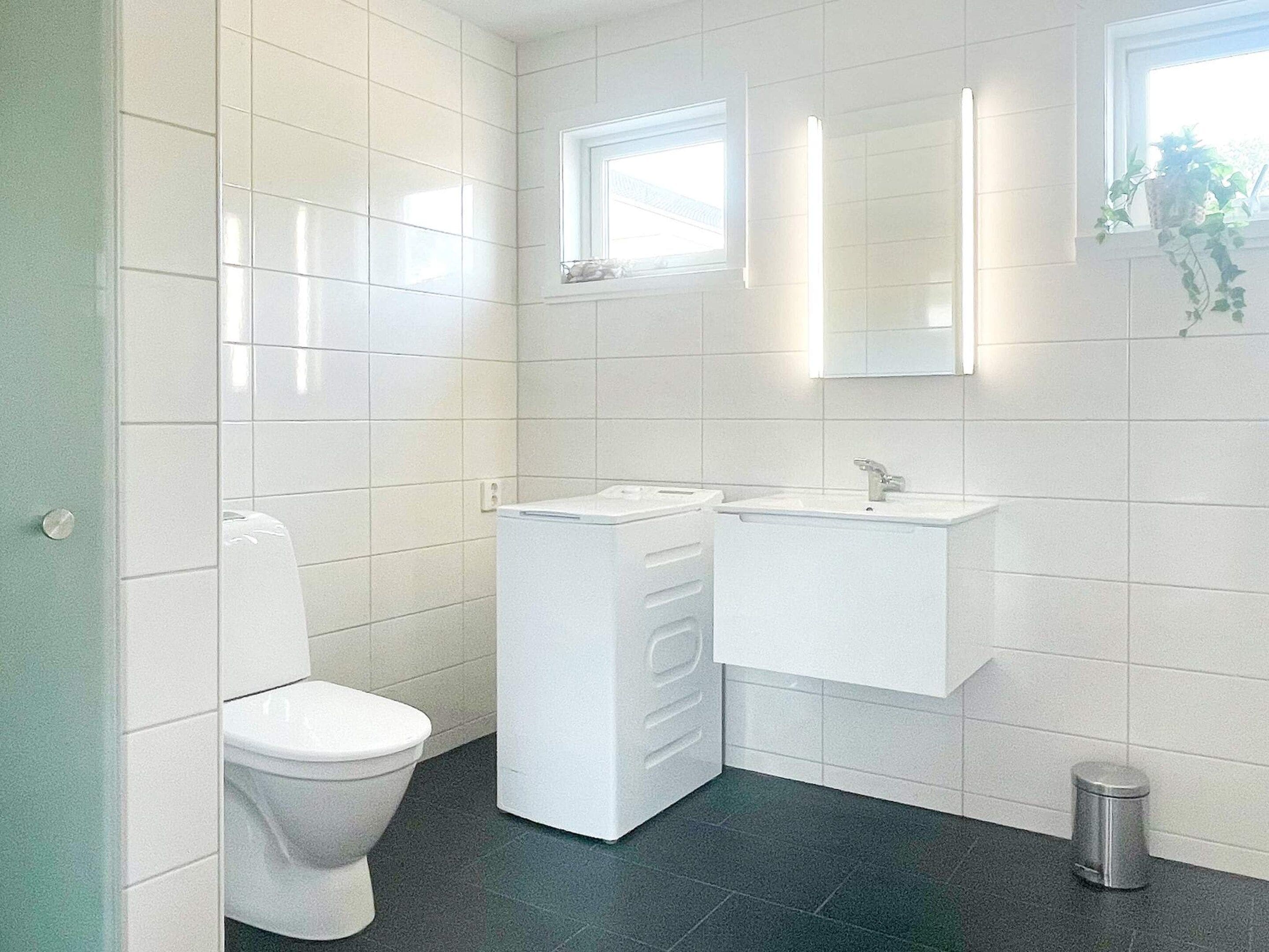A modern bathroom with a toilet, a sink, and a mirror.