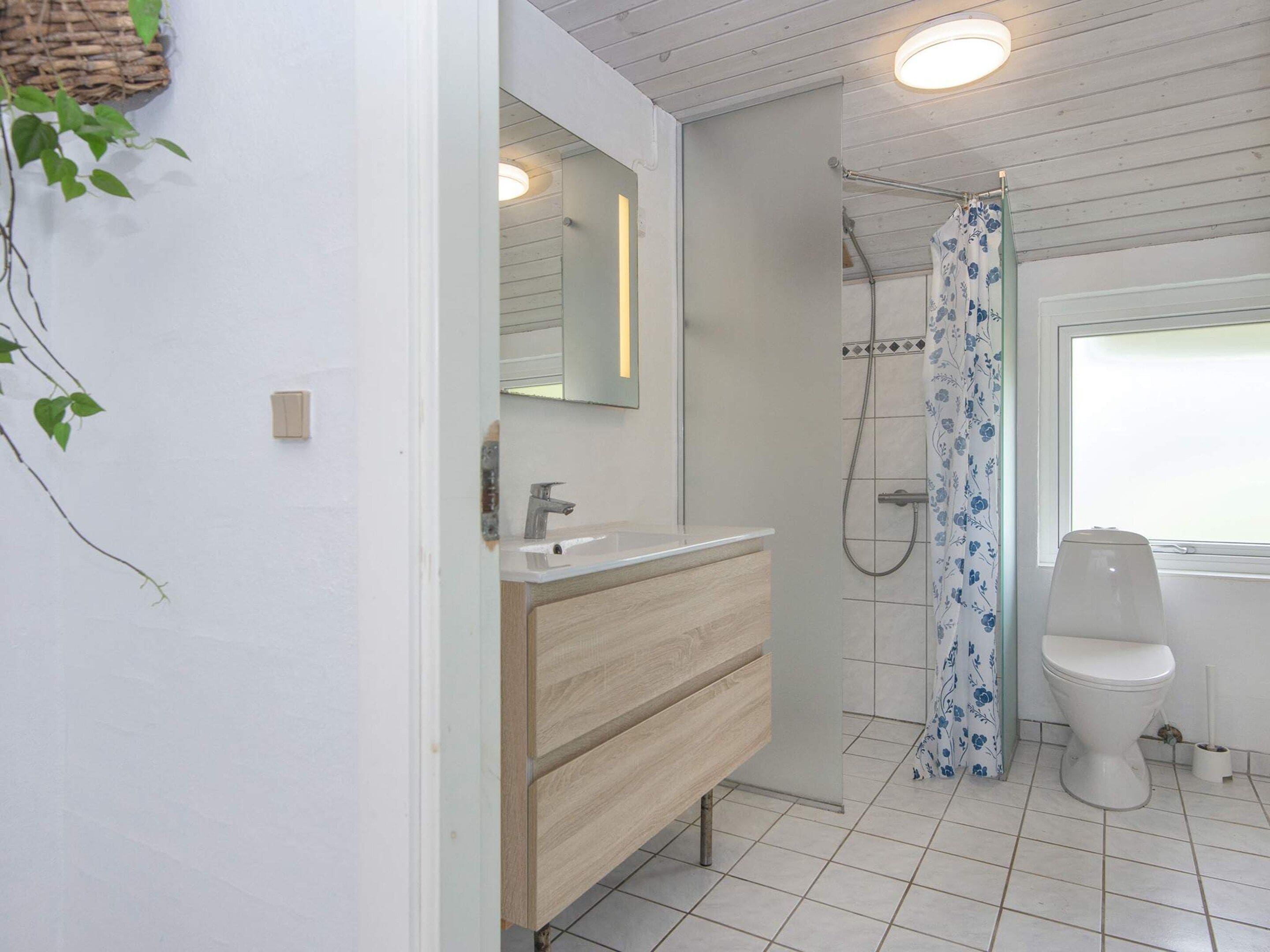 A bathroom with a shower, toilet, and sink.