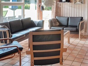 A living room with a sofa, a chair, and a small table. - 4 Star Holiday Home in Nordborg (Nordborg)