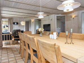 Ein Holztisch mit Stühlen, eine Vase mit Blumen und zwei Kerzenständern.