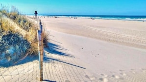 Ein Strand mit einer Umzäunung und einem Rettungsturm.