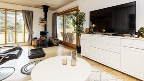 A modern living room with a large TV, a fireplace, and a balcony with outdoor furniture. - 5 Person Holiday Home in Gedser (Gedser)