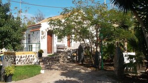 A house with a stone wall, a wooden door, and a bench outside. - Country House Buenavista Near Sea Beach (Buenavista del Norte)