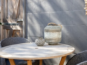 A round wooden table with two decorative metal containers and wicker chairs. - Holiday Home Near Beach With Garden (Kamperland)