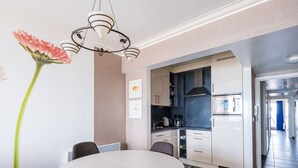 A modern kitchen with white cabinets, a black countertop, and a stainless steel oven. - Apartment on the 7th Floor With sea View (Middelkerke)