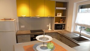 A modern kitchen with a central island, a microwave, and a sink. - Rebenrain Comfortable Holiday Residence (Steinach)