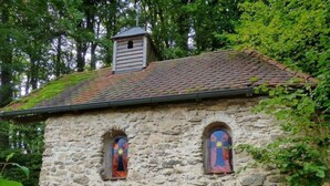 A stone building with two arched windows and a small chimney. - Oberprill Modern Retreat (Loitzendorf)