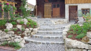 Un bâtiment rustique en bois, avec un escalier en pierre menant à une porte en bois.