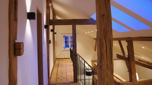 Un escalier en bois menant à une pièce dotée d’une lucarne.