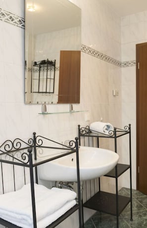 A bathroom with a white sink, black metal shelves, and a mirror above the sink. - Spreewald Break Modern Retreat (Burg (Spreewald))