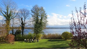 Un parque con zona de picnic, bancos y vistas a un lago.