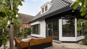 A modern house with a white exterior, black trim, and a tiled roof. - Holiday Home With a Garden and Parking (Drachten)