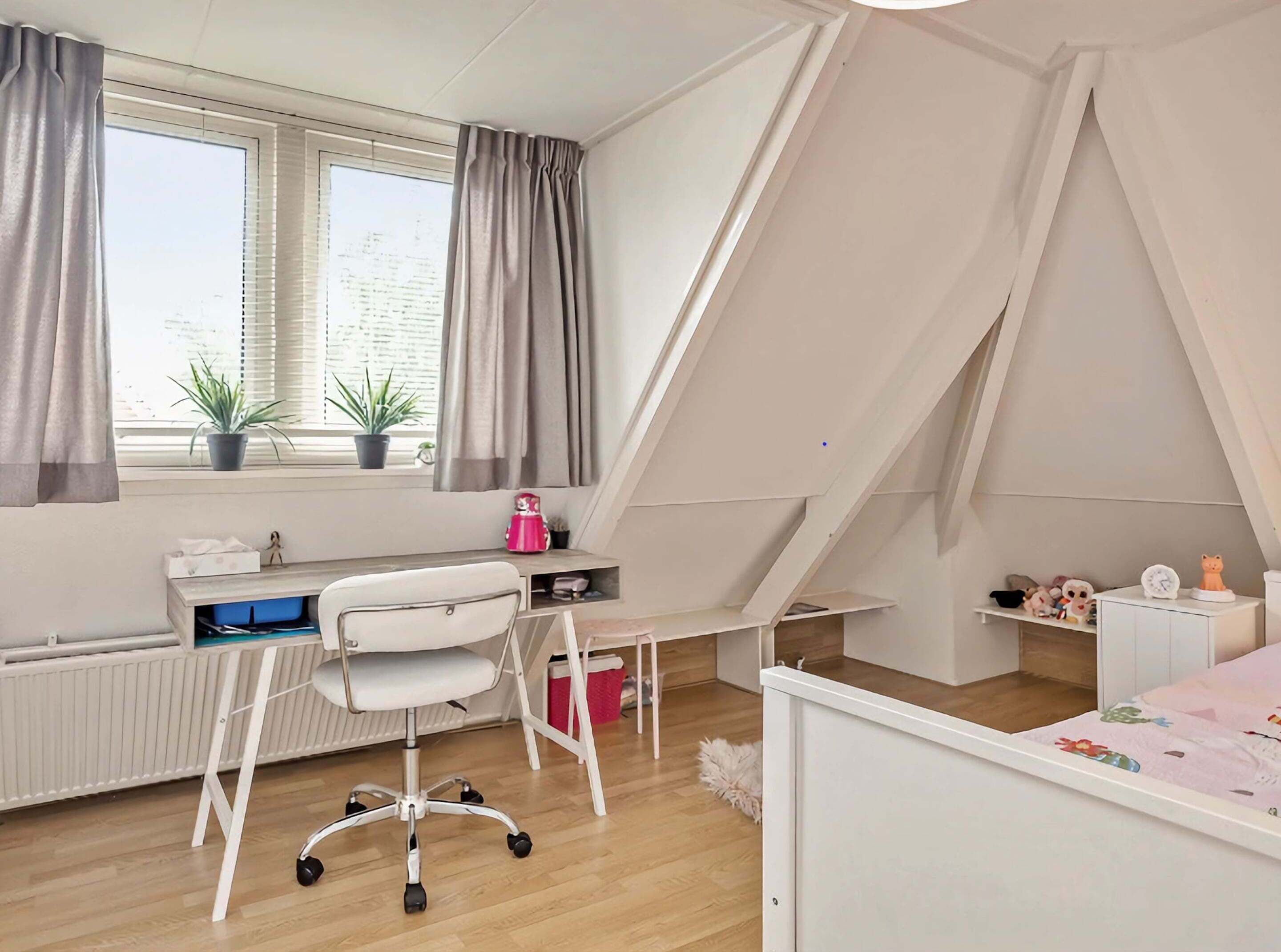 A child's bedroom with a desk, chair, and a bed.