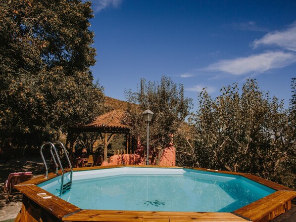 A rectangular wooden pool with a ladder, surrounded by trees and a gazebo. - Country House in Gran Canaria With Private Pool (Vega de San Mateo)