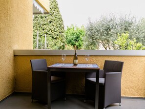 A balcony with a table and two chairs, a bottle of wine, and a glass on the table. - Directly on the Lake - Casa San Benedetto (Peschiera del Garda)