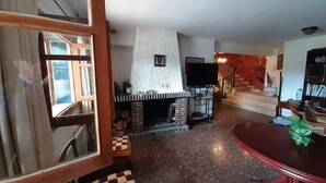 A living room with a fireplace, a staircase, and a dining area. - Villa Near Valencia With Private Pool (Chulilla)