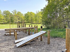 An outdoor playground with wooden structures and a wooden slide. - 4 Person Holiday Home in Gusum (Valdemarsvik)