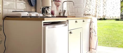 A kitchen with a built-in dishwasher, a coffee maker, and a sink.