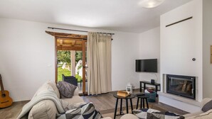 A living room with a sofa, a television, a fireplace, and a guitar. - Villa Casa Ida Comfortable Holiday Residence (Groznjan)