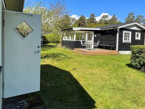 A house with a covered porch, a small deck, and a door with a window. - 4 Star Holiday Home in Solvesborg (Sölvesborg)