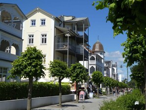 Eine Straße gesäumt von mehrstöckigen Gebäuden, darunter ein Gebäude mit einer Kuppel und Balkonen.