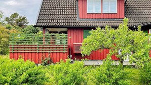 A red house with a tiled roof and a green fence. - 4 Star Holiday Home in Grisslehamn (Grisslehamn)