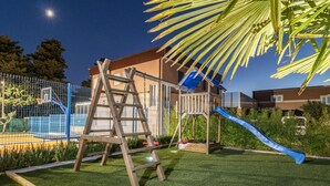 A playground with a slide, climbing structure, and basketball hoop. - Istra Kamen Comfortable Holiday Residence (Liznjan)